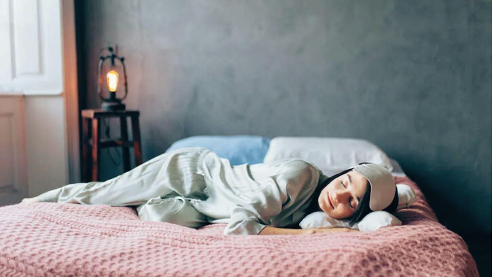 Woman wearing eye mask trying to sleep, illustrating fatigue and restlessness caused by hangxiety