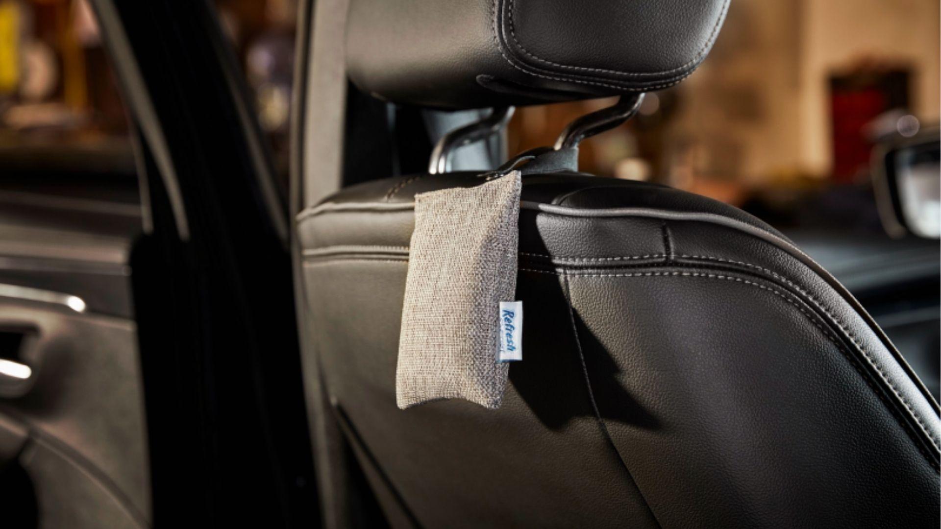Natural charcoal air purifier bag hanging on car seat headrest to absorb weed smell