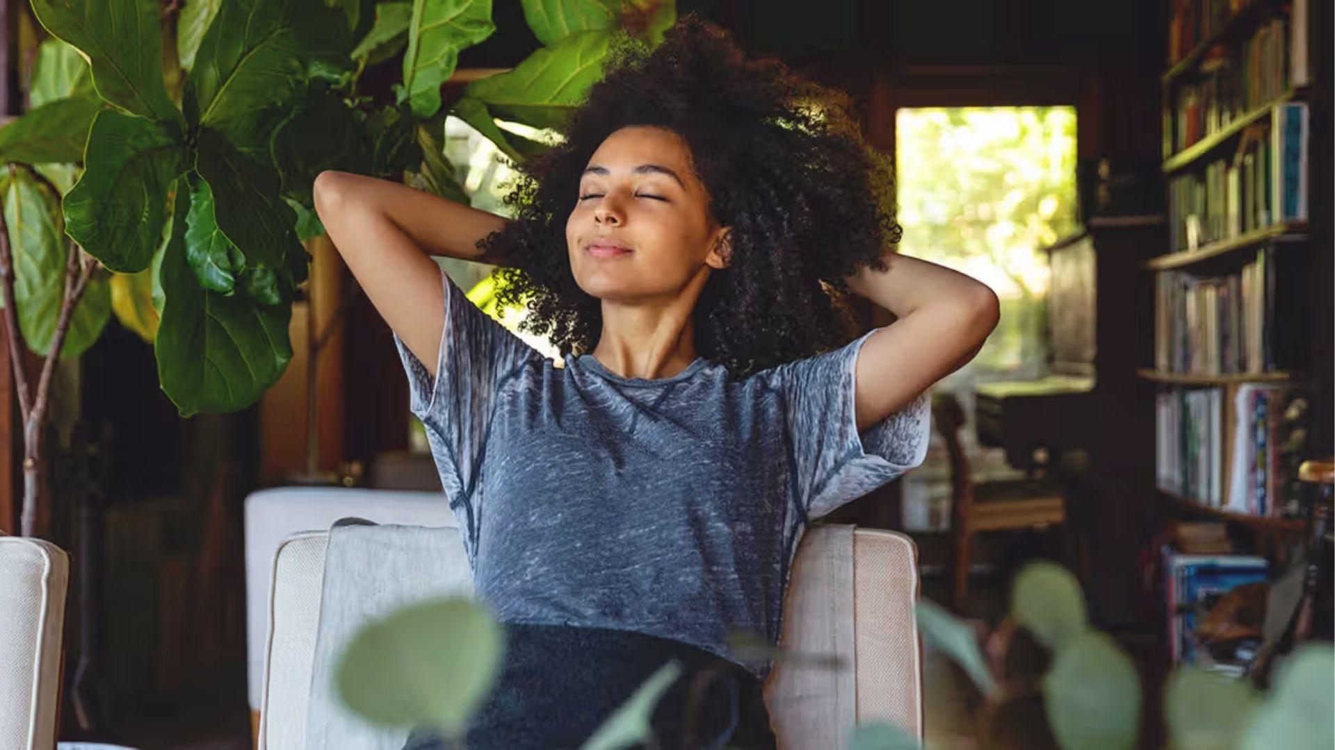 Relaxed woman with eyes closed at home, showing how mindfulness helps reduce hangxiety symptoms