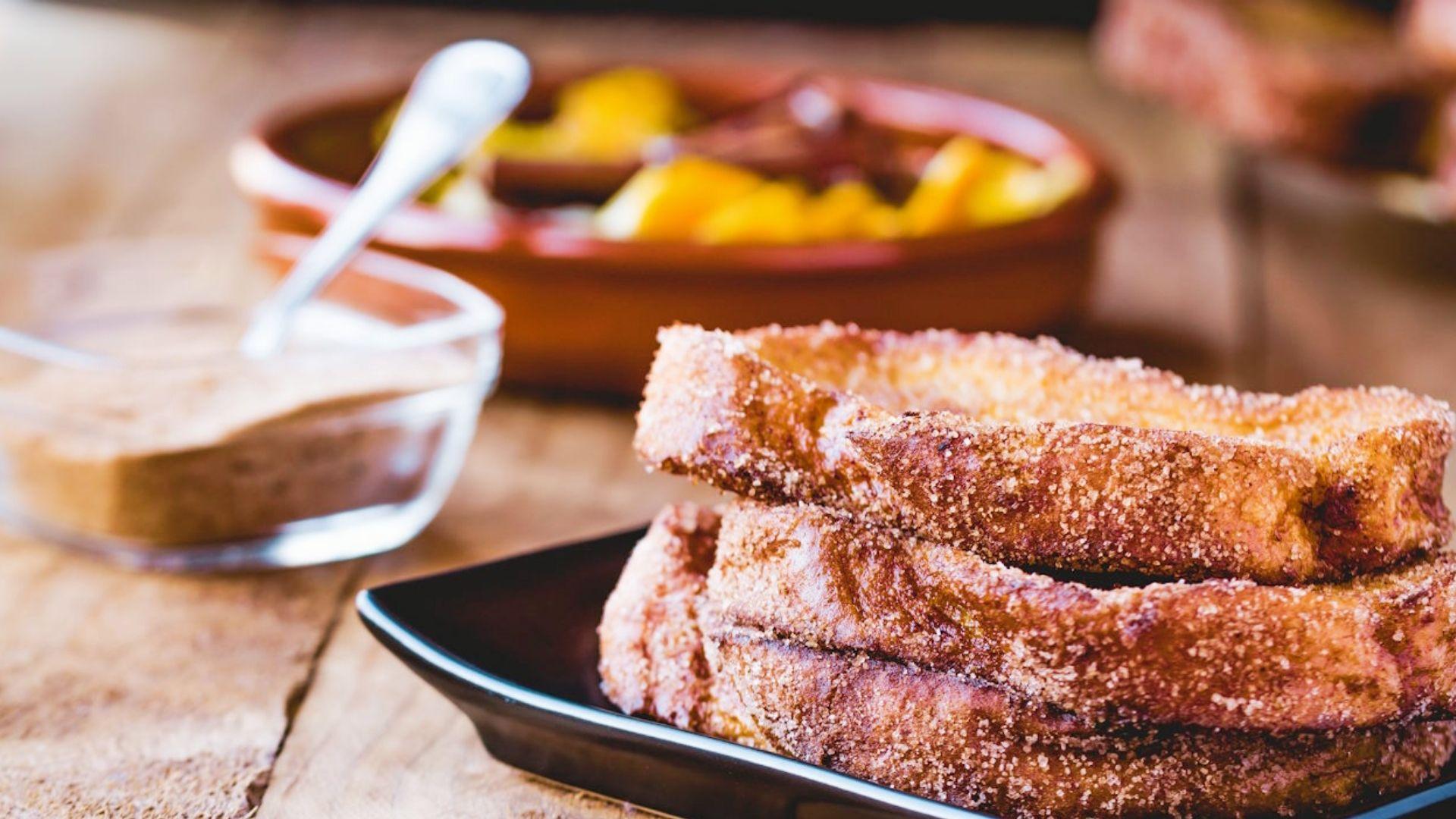 Cinnamon sugar cannabis French toast slices stacked on black plate for infused breakfast or brunch recipes