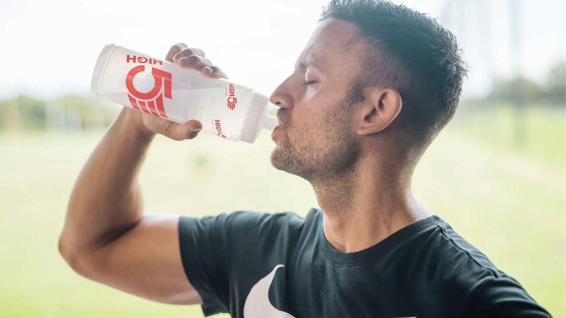 Man rehydrating outdoors with water bottle, showing how hydration helps reduce hangxiety symptoms after drinking alcohol