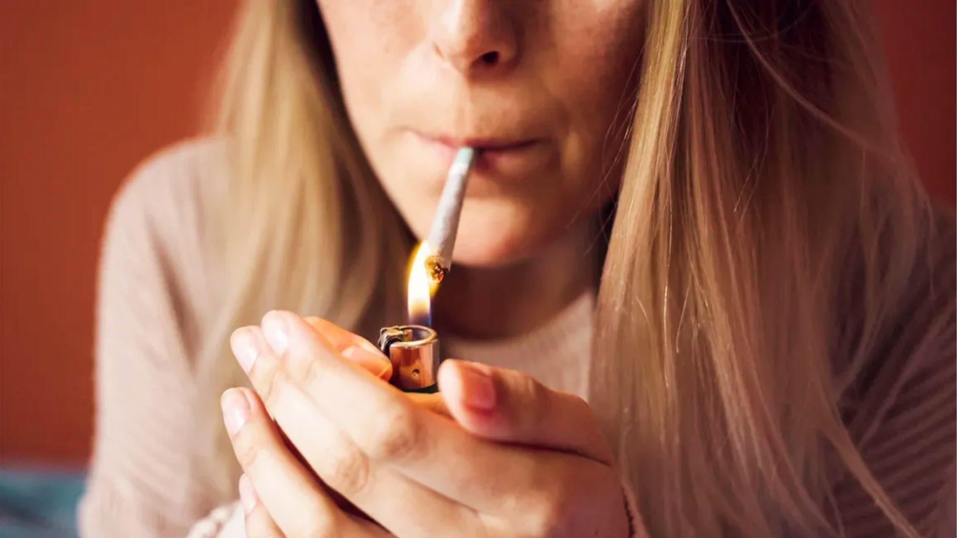 Close-up of woman lighting cannabis joint with lighter, comparing smoking effects to cannabis edibles