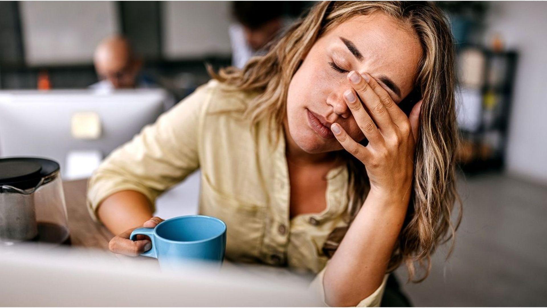 Woman holding tea calmly indoors, showing a gentle way to reduce hangxiety symptoms