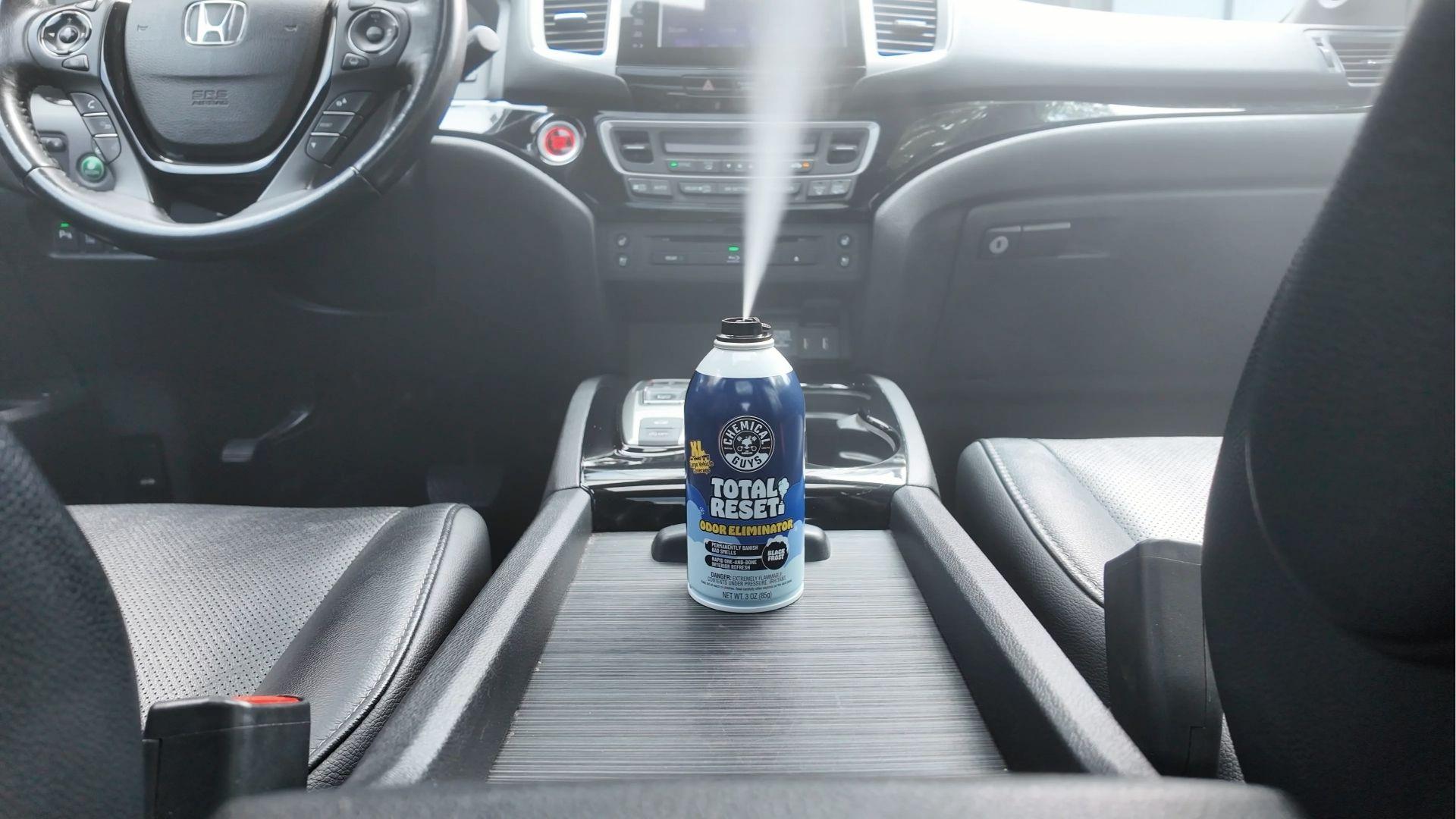 Odor eliminator spray misting inside car center console to neutralize weed smell fast